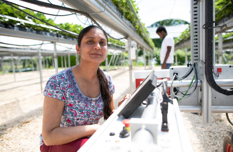 Woman smiling and working with technology equipment in an agricultural space 