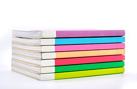 A stack of colorful books on a white table