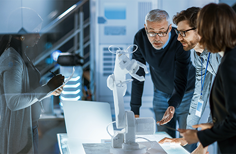 Scientists in a lab looking at a robotic arm