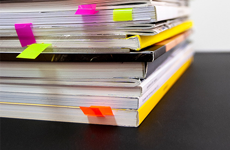 A stack of books with post-it notes saving pages