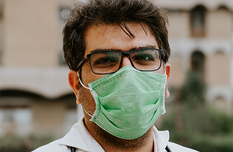 A person wearing glasses and a surgical mask