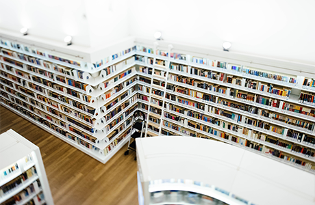 A view from above of white library shelves lined with colorful books