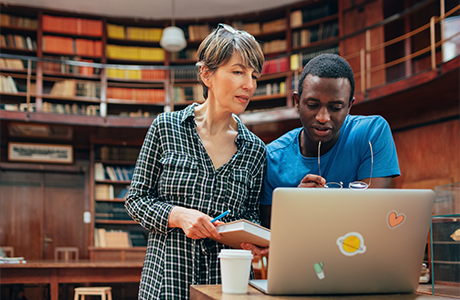 Two people in a library looking at a computer