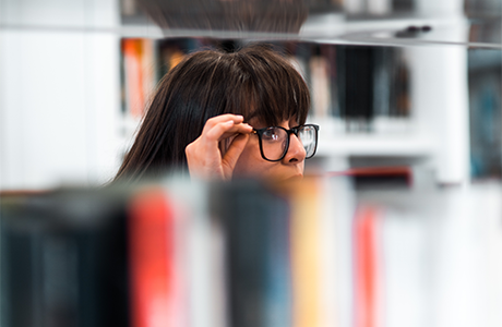 A person looking at books on a shelf